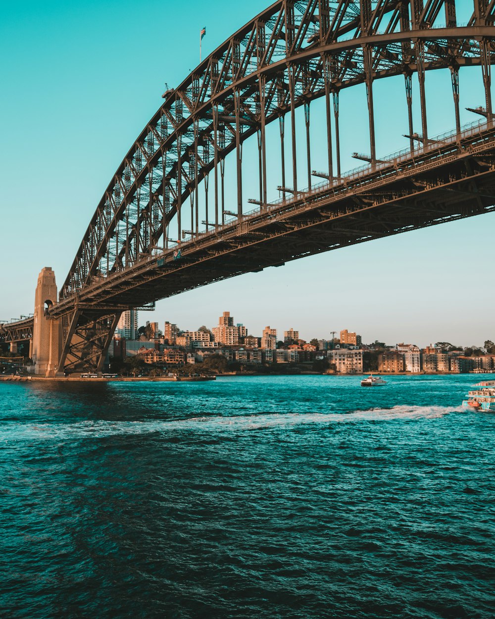 gray concrete suspension bridge near city under clear blue sky