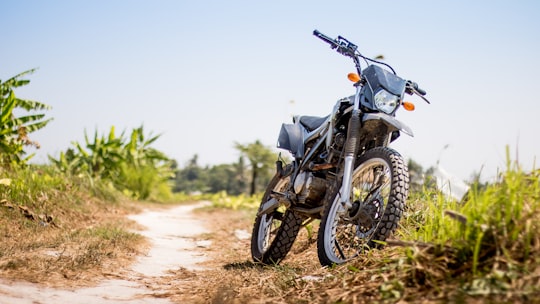 black and gray motorcycle park near grass at daytime in Canggu Indonesia