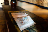 Close-up of an open book with vibrant illustrations on a cozy wooden desk.