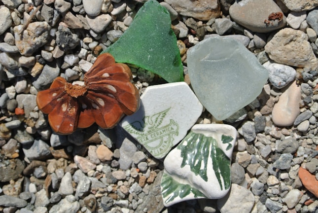 Close-up of vibrant cobalt blue sea glass pieces resting on volcanic black sand.