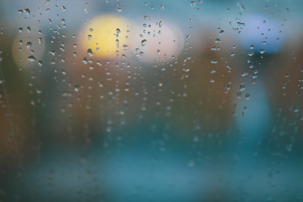 rain drops on a window with blurry buildings in the background