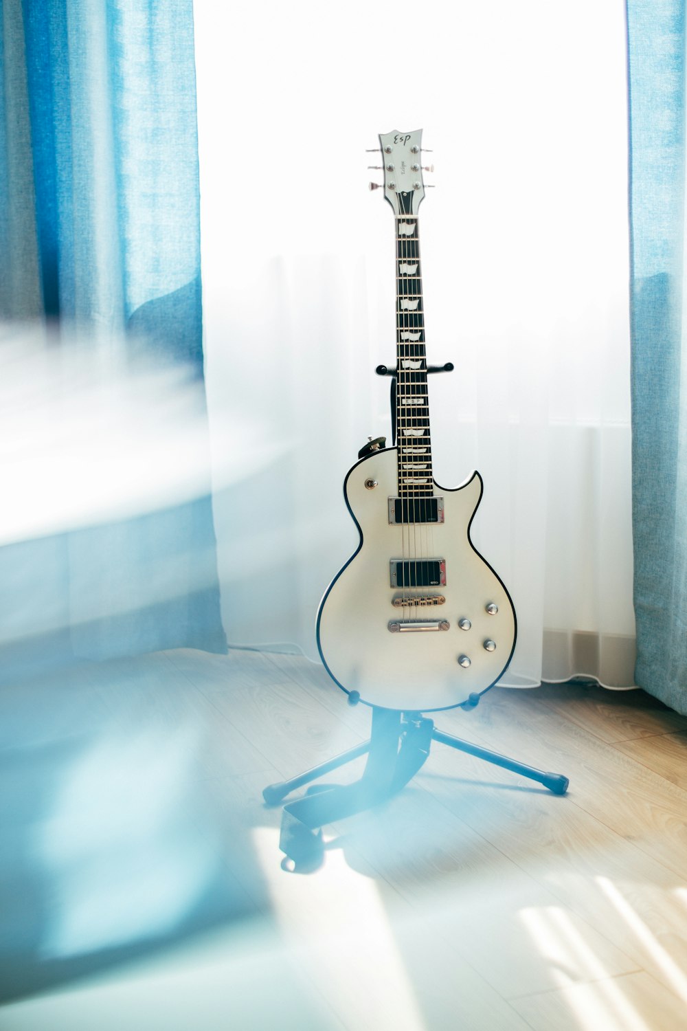 white Les Paul guitar with stand