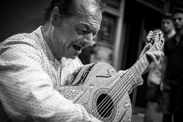 Close-up of a young artist passionately playing guitar during a reggae cultural event.