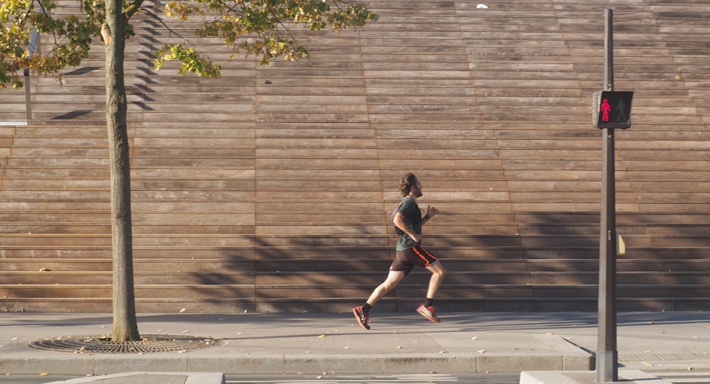 man running on pathway near traffic light