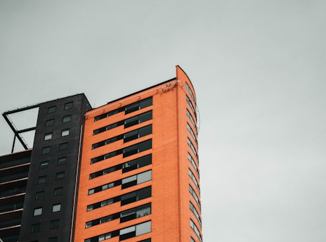 Modern prefabricated building under construction with black and orange accents.