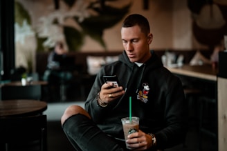 A man wearing a trendy hoodie while enjoying coffee at a café.