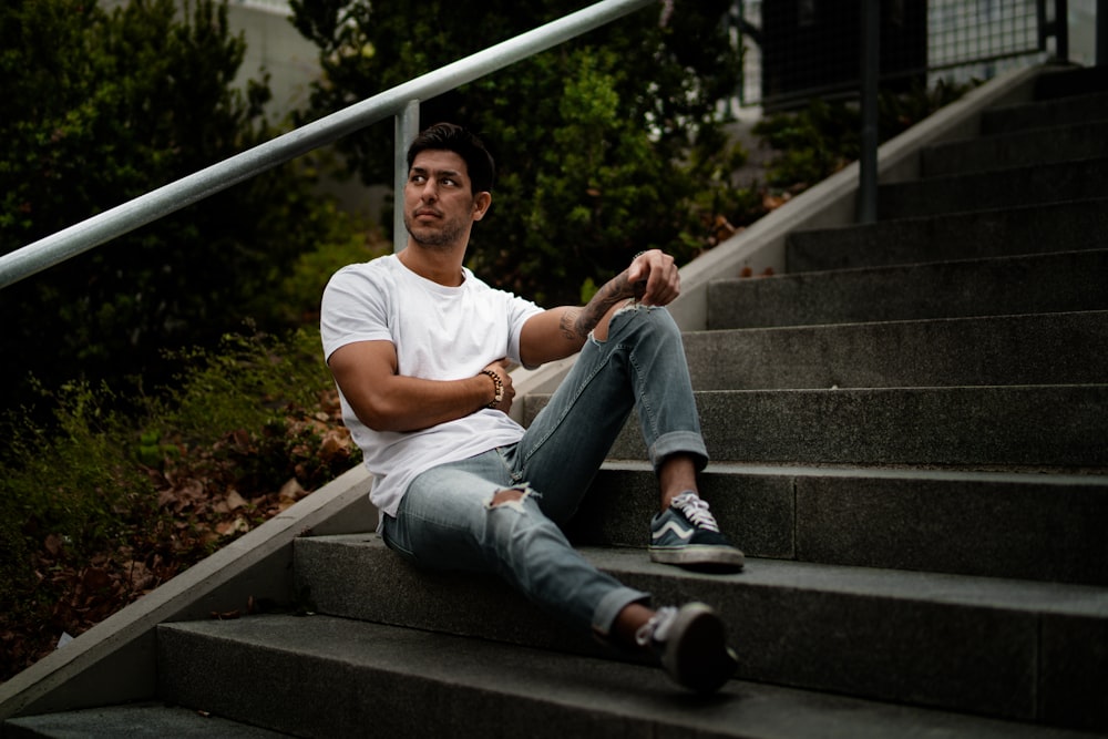 man sitting on stairs leaning against rail