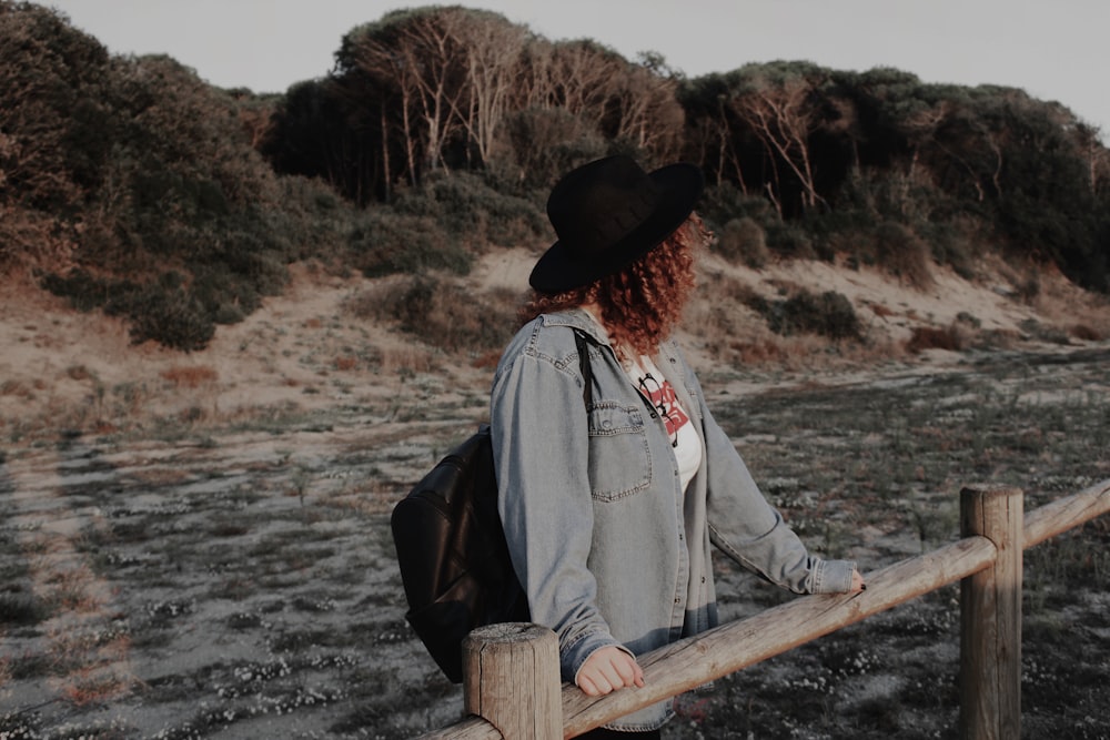 woman holding onto log looking towards left