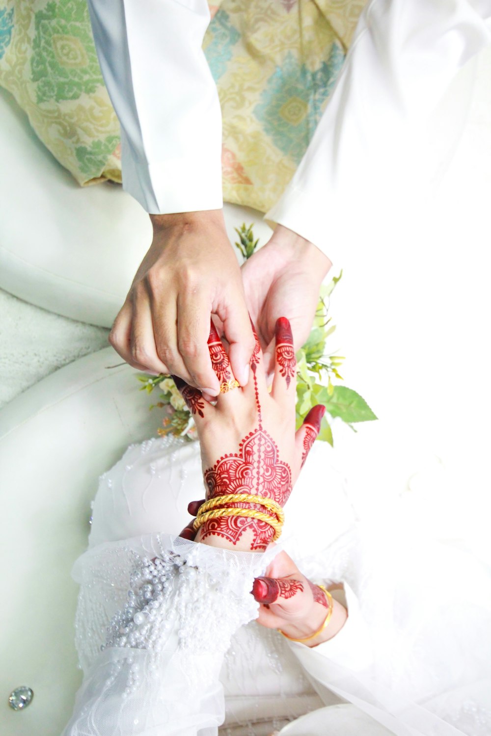 person holding hands with red Mendhi tattoo