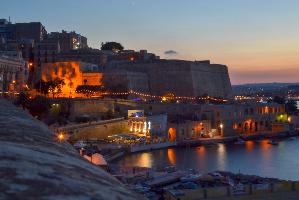 city beside body of water during sunset