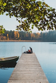 Man on a dock with autumn foliage on Kahshe Lake.