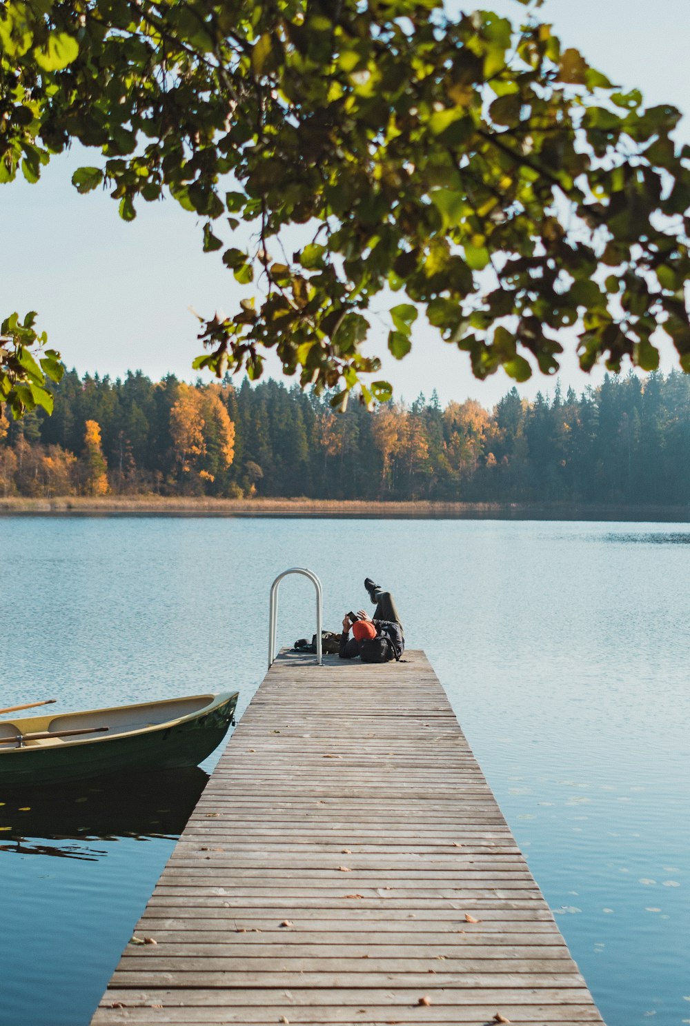 black and gray boat besides brown wooden dock at daytime