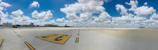 Wide-angle shot of a commercial airport runway with visible rejuvenation markings.