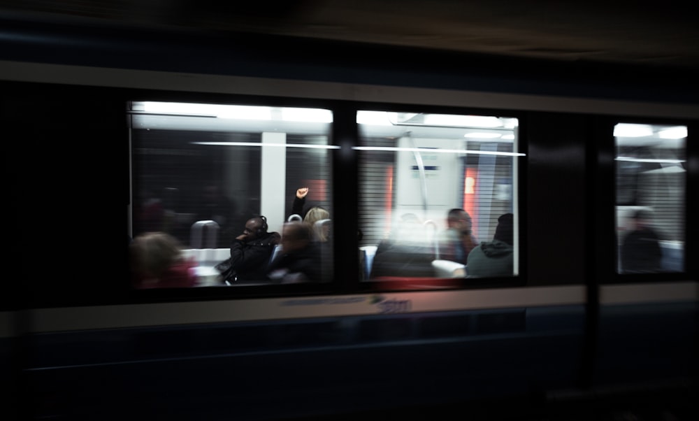 a group of people sitting on a train at night