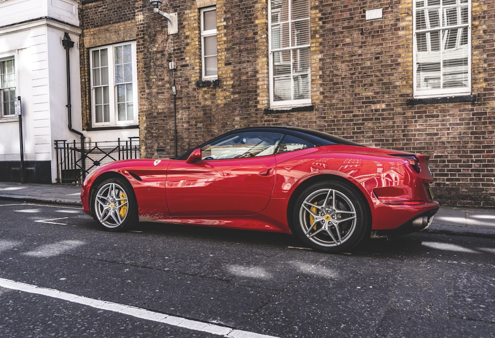 red coupe parks beside house