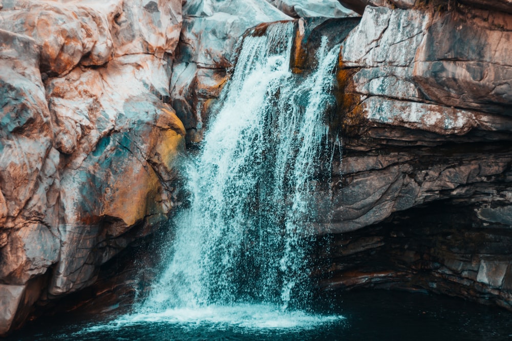 water falls on brown rocks