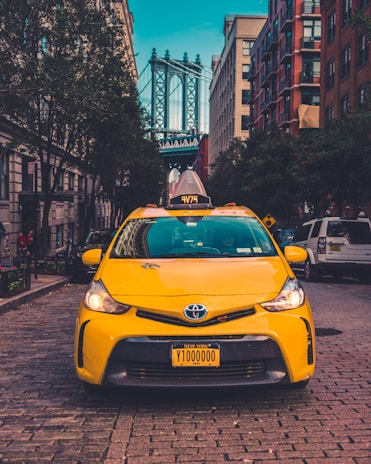yellow Toyota taxi cab parked near building