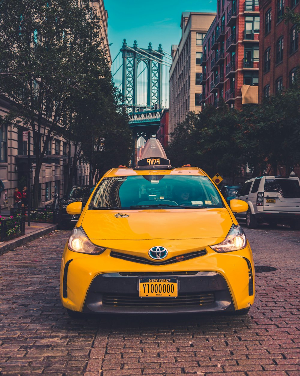 yellow Toyota taxi cab parked near building