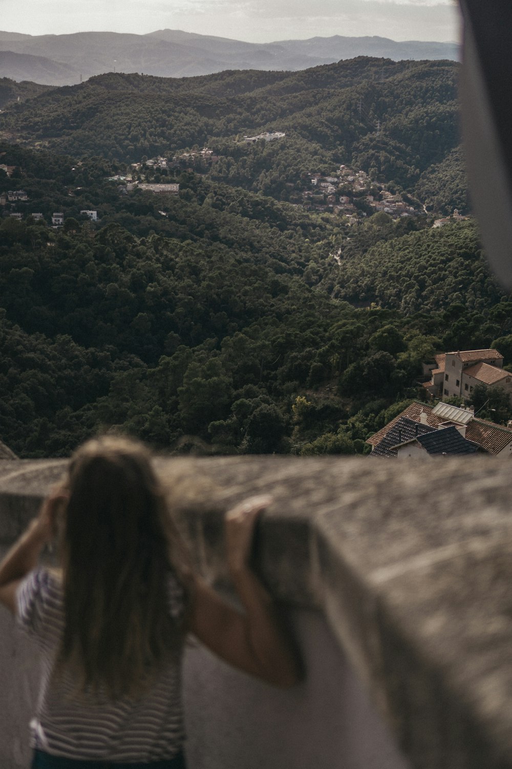 girl standing near concrete railings viewing mountain