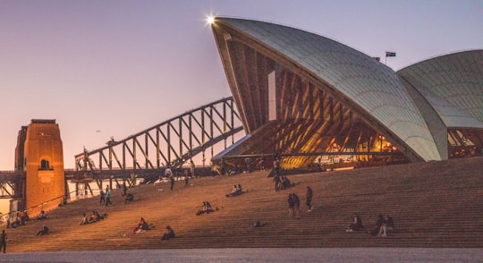 group of people sitting near stadium in Sydney Harbour Bridge Australia