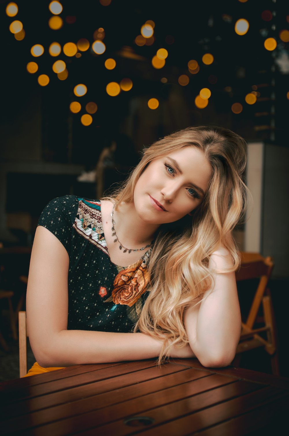 woman sitting in front of table with bokeh effects