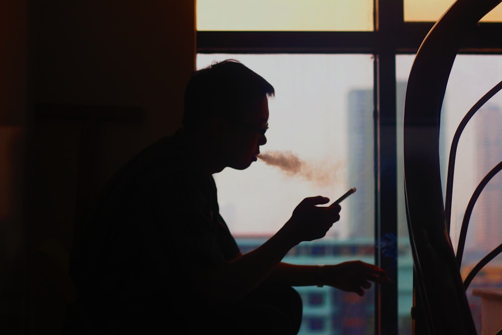 silhouette of man smoking cigarette