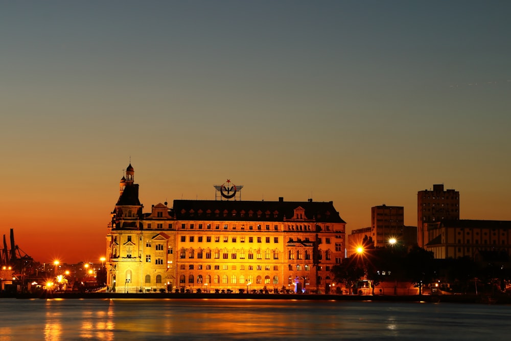 body of water near lightened building at night