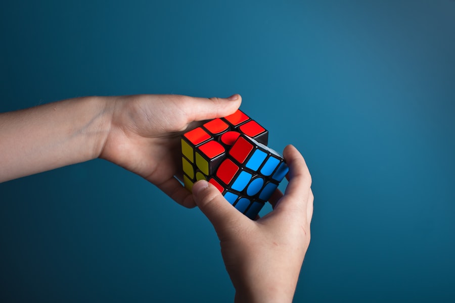 Two hands holding a Rubik's Cube that is mostly solved.