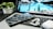 A close-up of a person working on a laptop with technology gadgets around.
