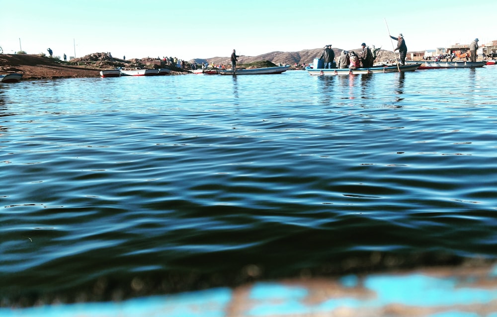 people riding boats on body of water during day