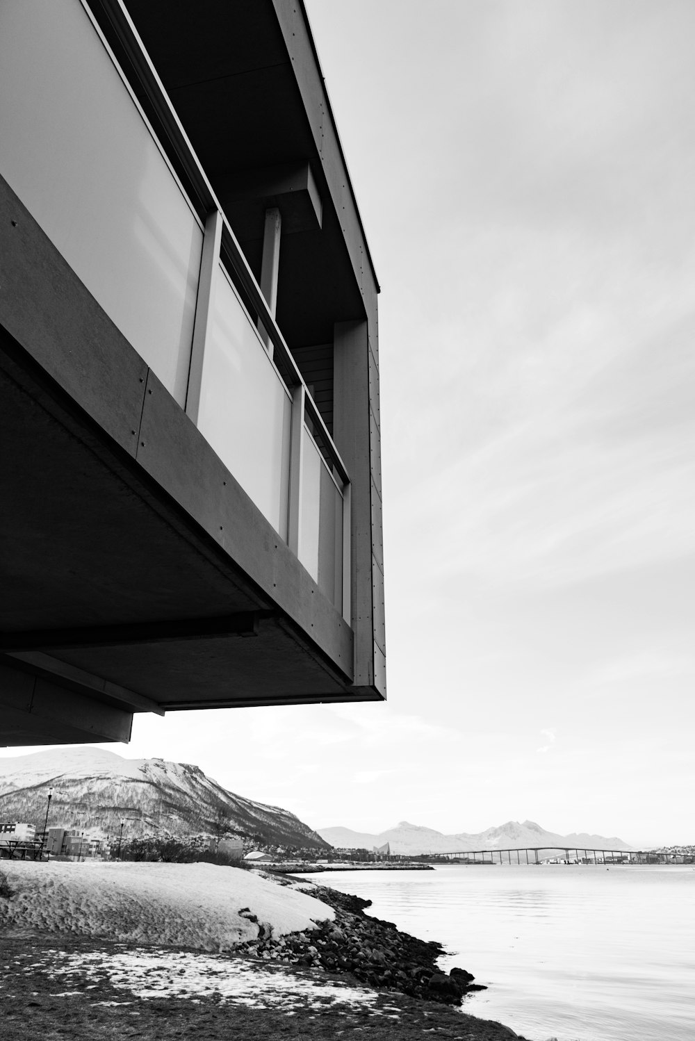 grayscale photo of building beside water