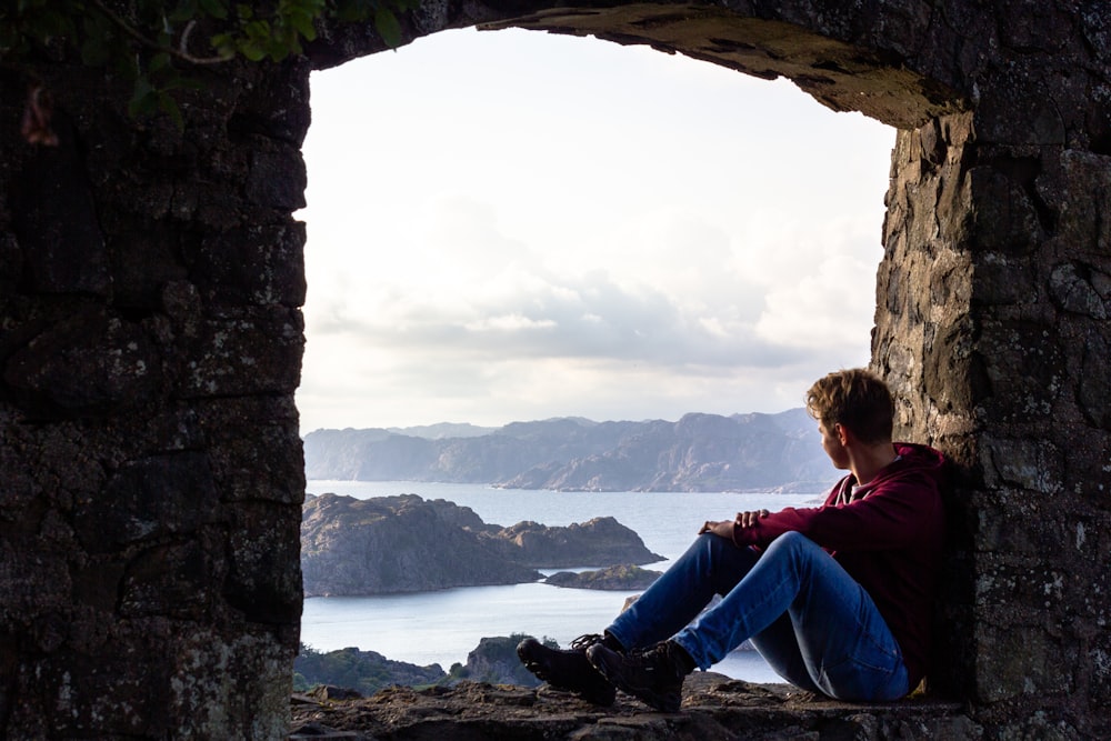 man sitting on window frame