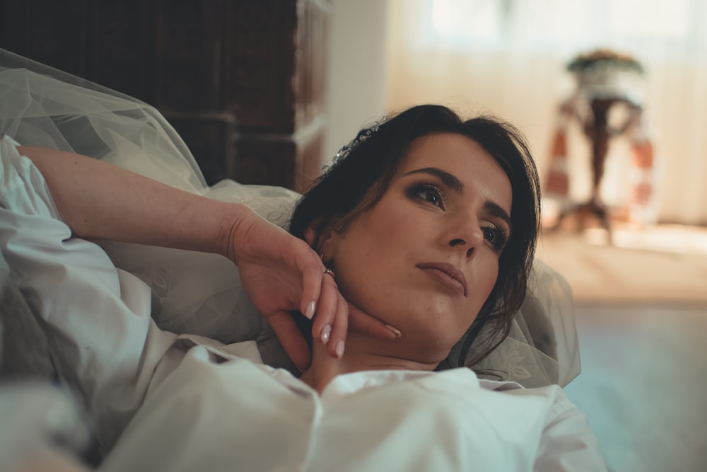 woman in white top lying on sofa