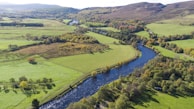 An aerial view of a winding river surrounded by rolling hills.