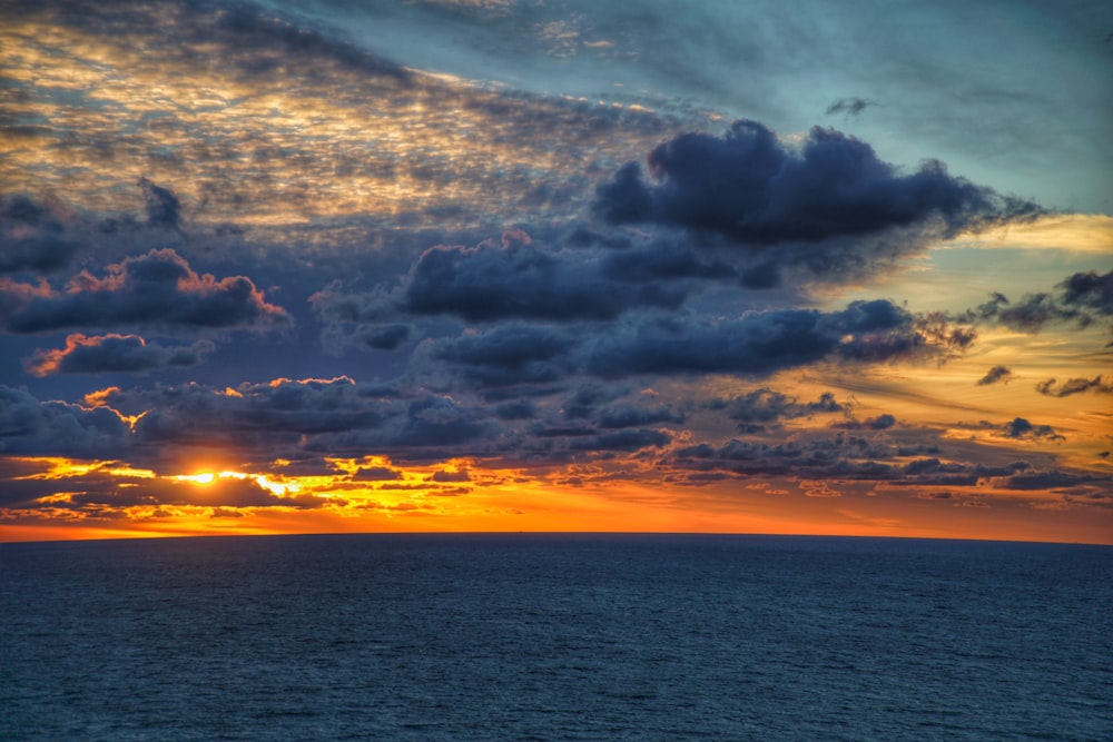 blue sea under gray cloudy sky