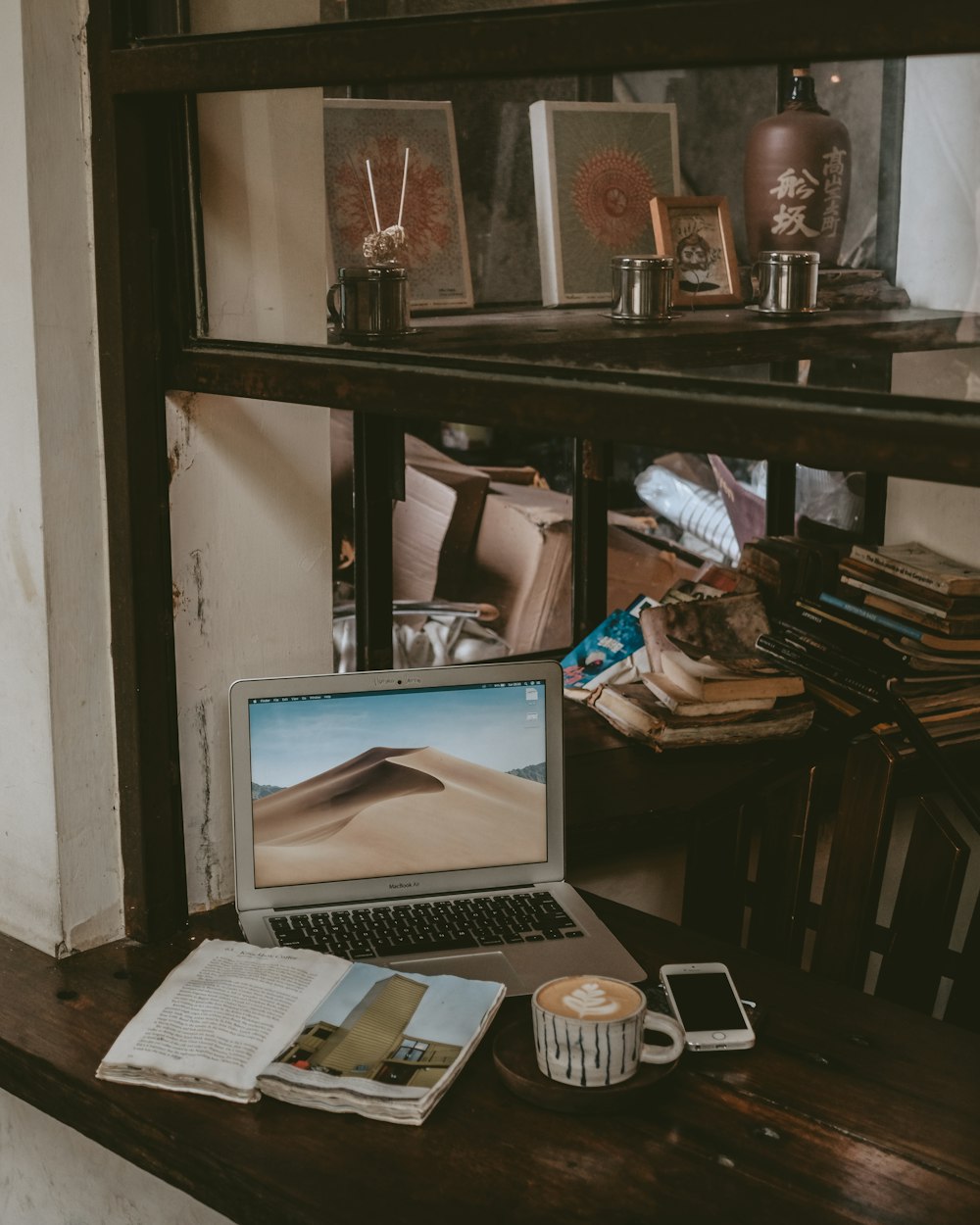 MacBook Air beside cup of coffee latte and smartphone