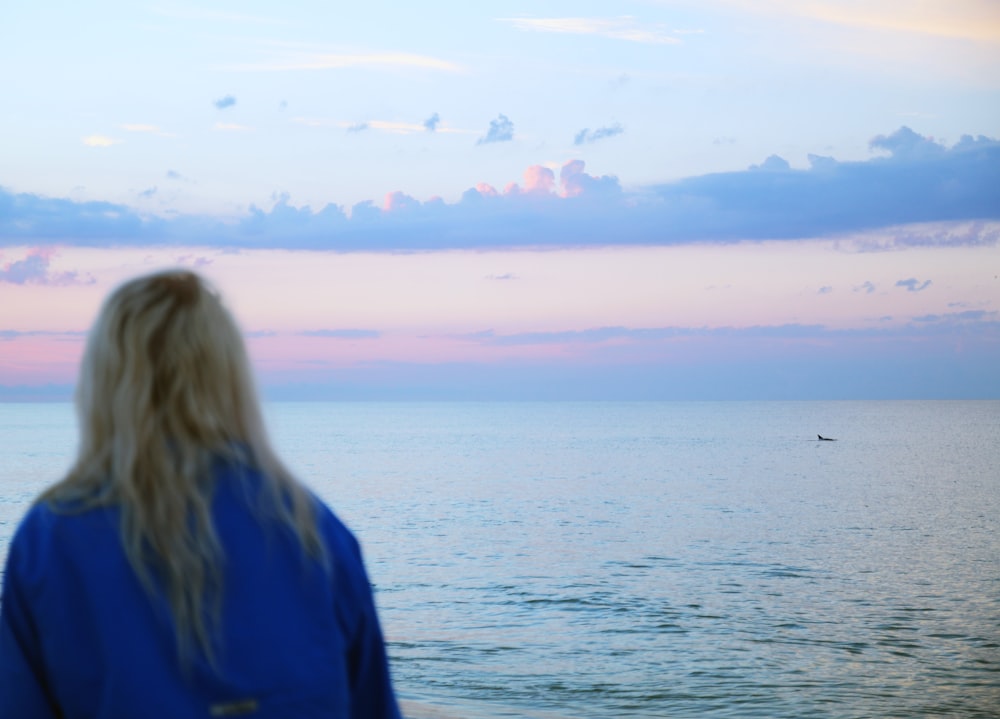 woman in blue top facing ocean