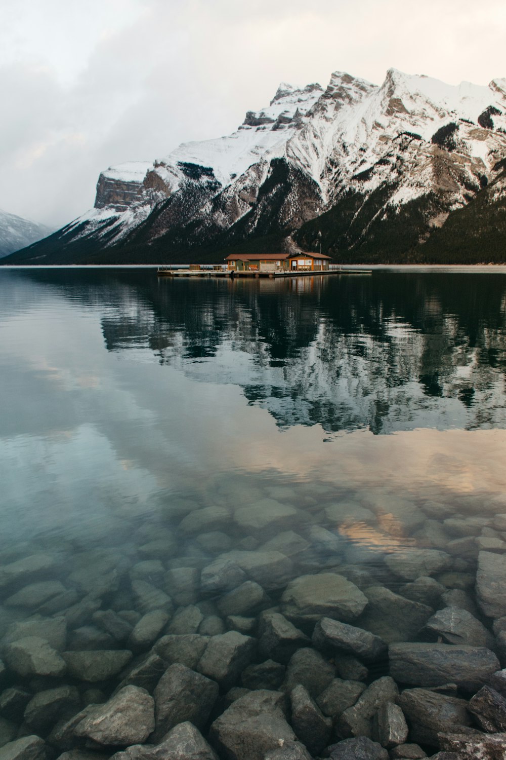 calm body of water near snow cape mountain