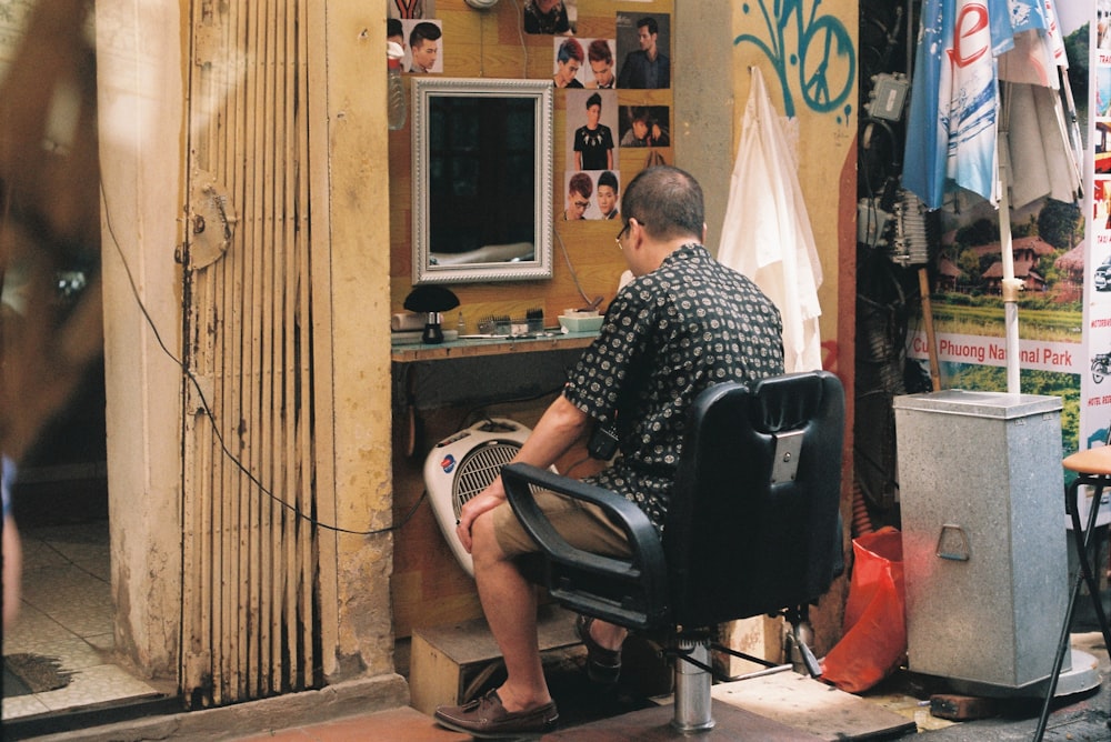 man sitting on barber chair