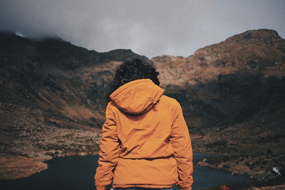 man standing front of lake at daytime