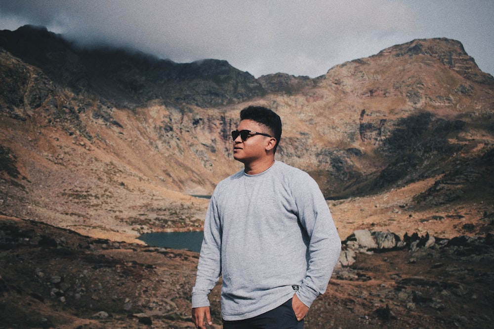 man wearing sweater and sunglasses with mountain background