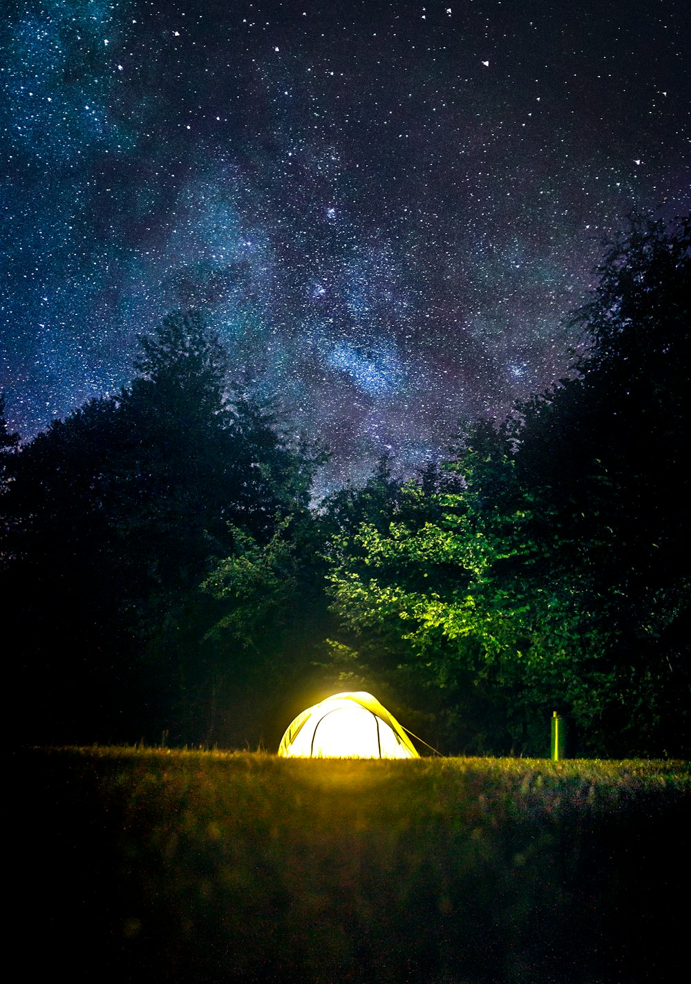 lighted green tent in forest during night time