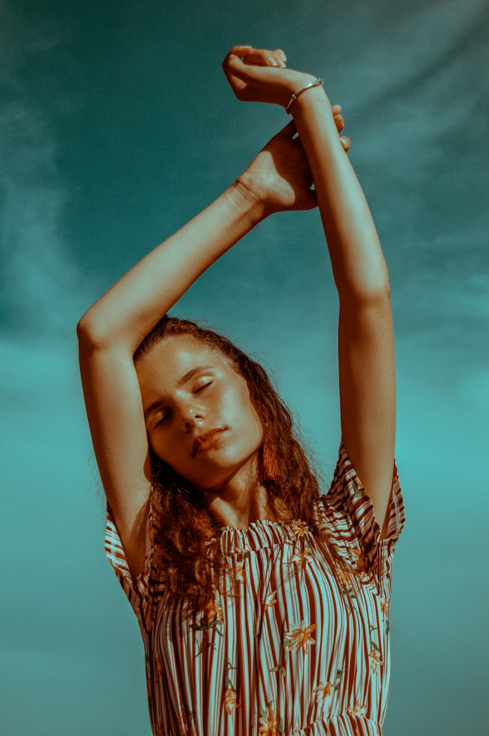 woman standing and raising both hands