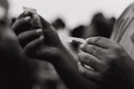 Close-up of hands holding a freshly rolled joint with a backdrop of the store's colorful interior.