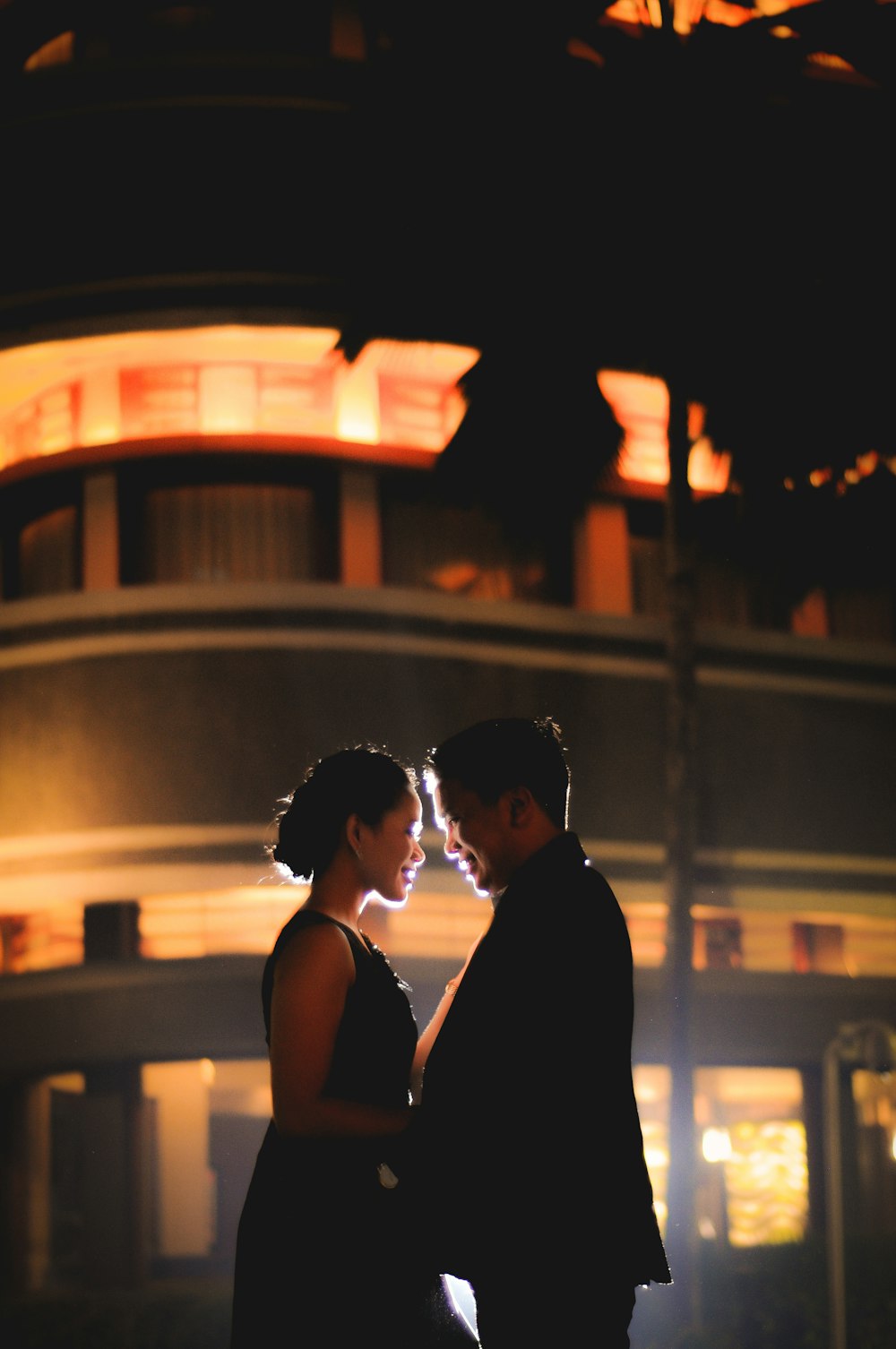 man and woman smiling while holding each other during nighttime