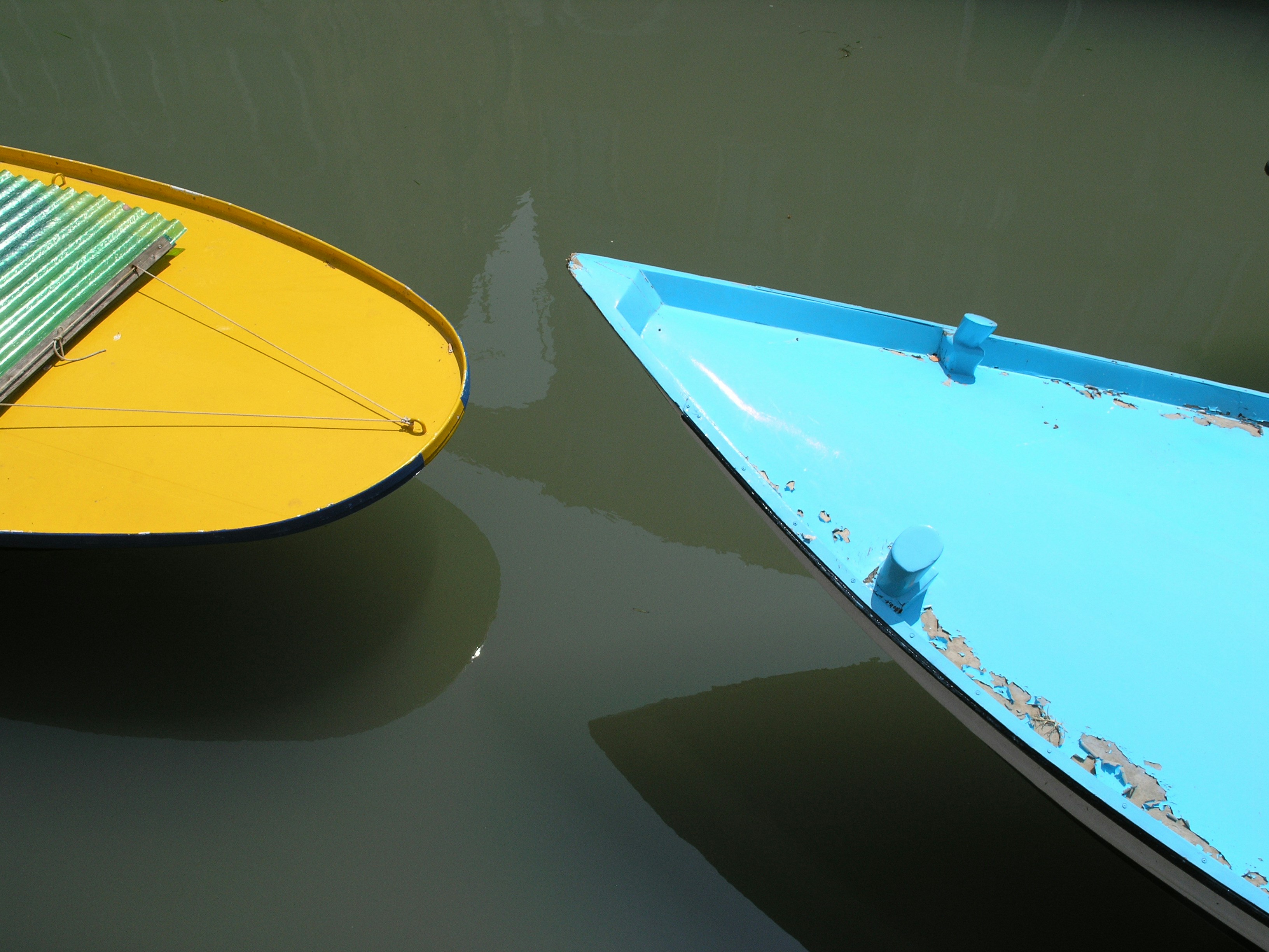 two teal and yellow boats on body of water at daytime