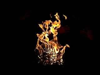 A glowing flame passing from mother’s hand to daughter’s hand, symbolizing generational fire.