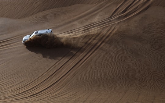 white SUV on desert in Abu Dhabi United Arab Emirates