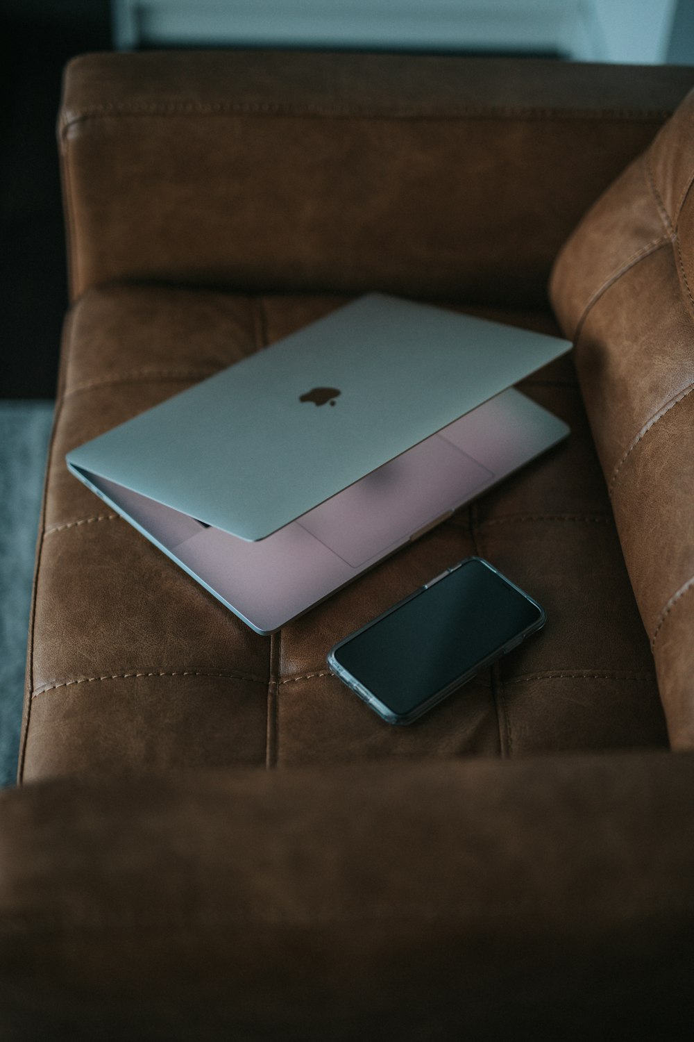 silver MacBook on sofa