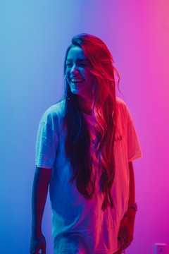 A vibrant photo showing a client with a fresh, colorful hairstyle smiling in natural light.